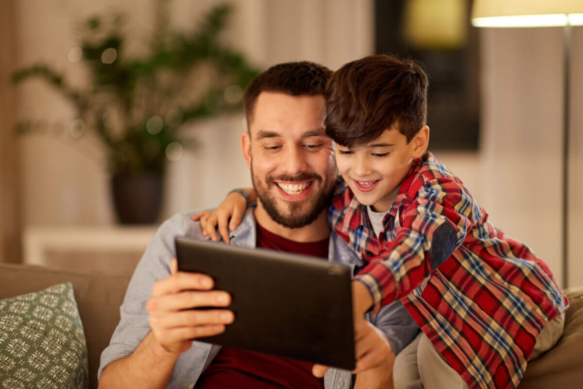father and son with tablet pc playing at home