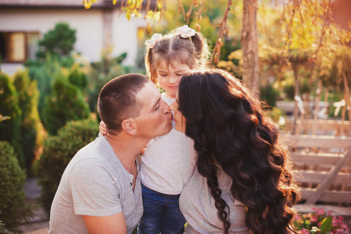 Parents kissing. Father, mother and small daughter