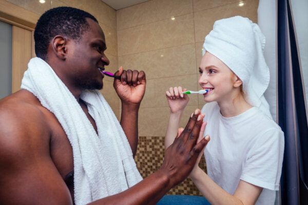 Couple sharing bathroom, brushing teeth together