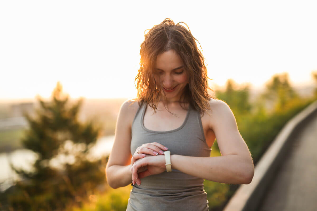 woman with fitness bracelet in sports in park