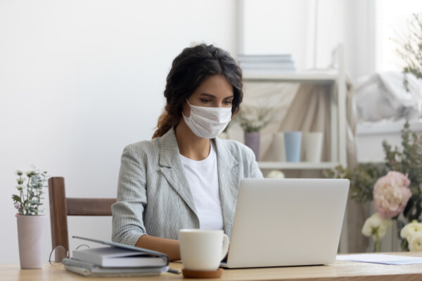 Woman wearing face mask while working during coronavirus outbreak