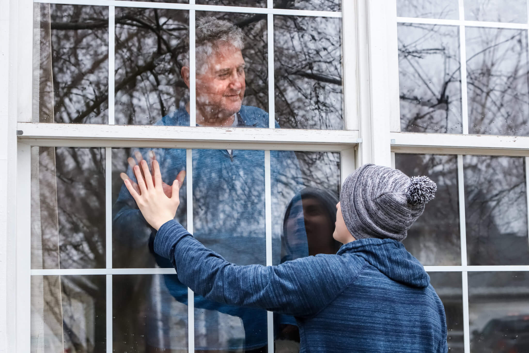 Social distancing - man at window during coronavirus lockdown