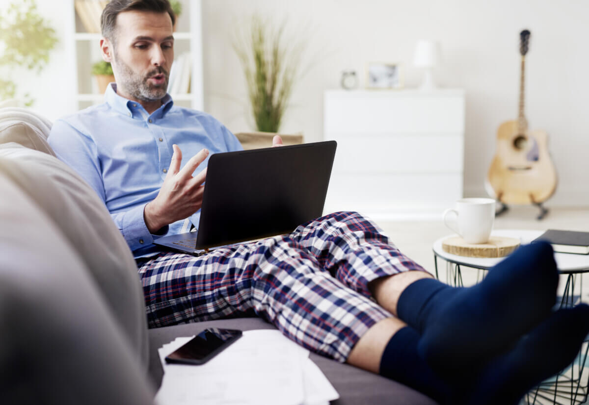 Man working on computer and wearing pajamas