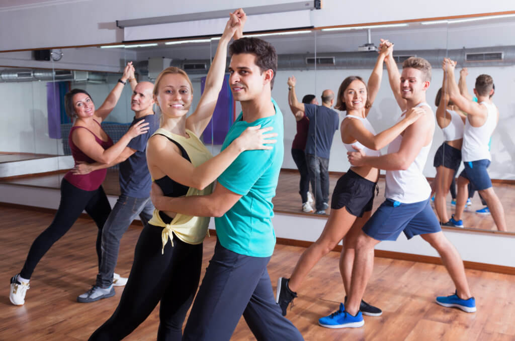 People taking dancing lessons in salsa dance class