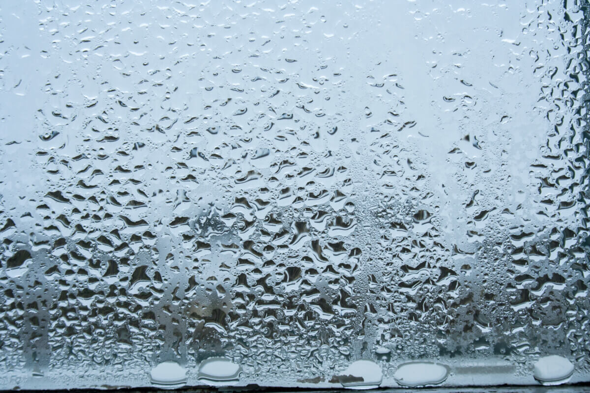 Steamy glass. Window covered with drops of water vapor