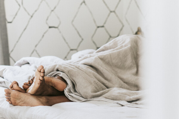 Couple in bed, feet sticking out of sheets