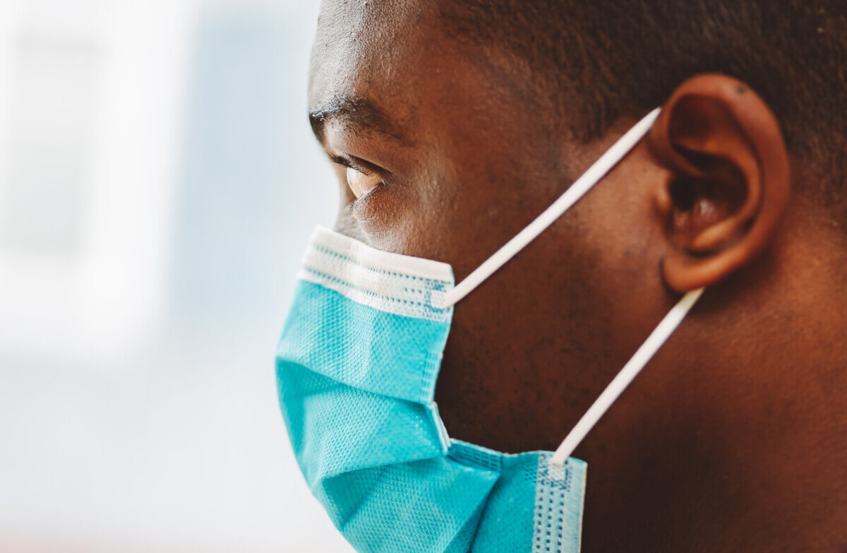 african american man in blue and white surgical  face mask