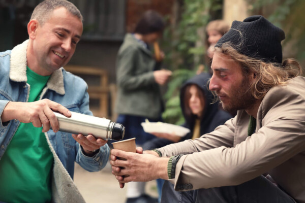 Man volunteering to feed homeless man