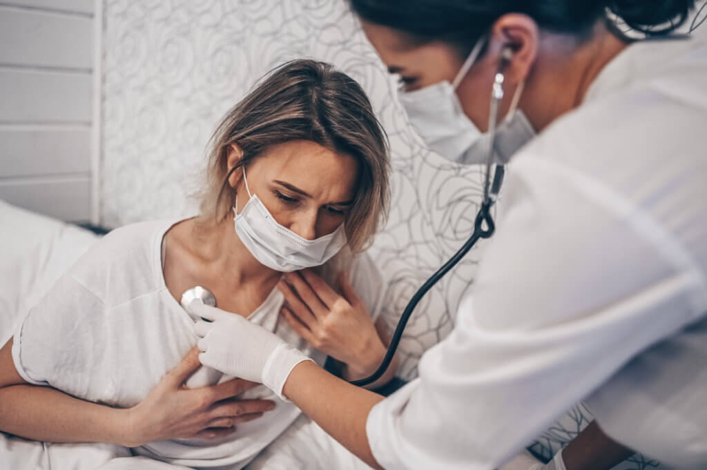 Doctor listening to coronavirus / COVID-19 patient having trouble breathing