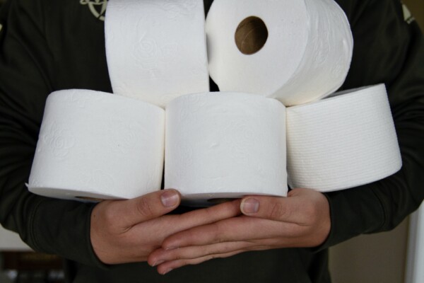 Person holding toilet paper stockpile