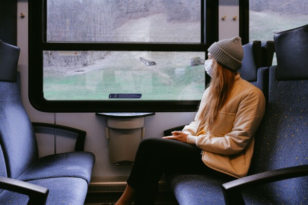Woman on train wearing mask during coronavirus / covid-19 outbreak