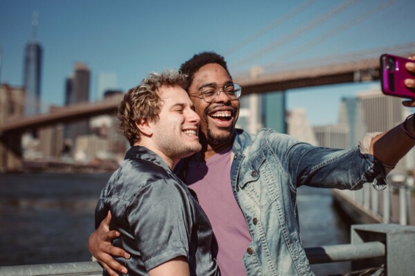 Men, couple taking selfie together