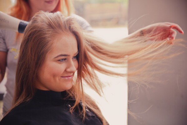 Woman getting a haircut, having her hair blown out