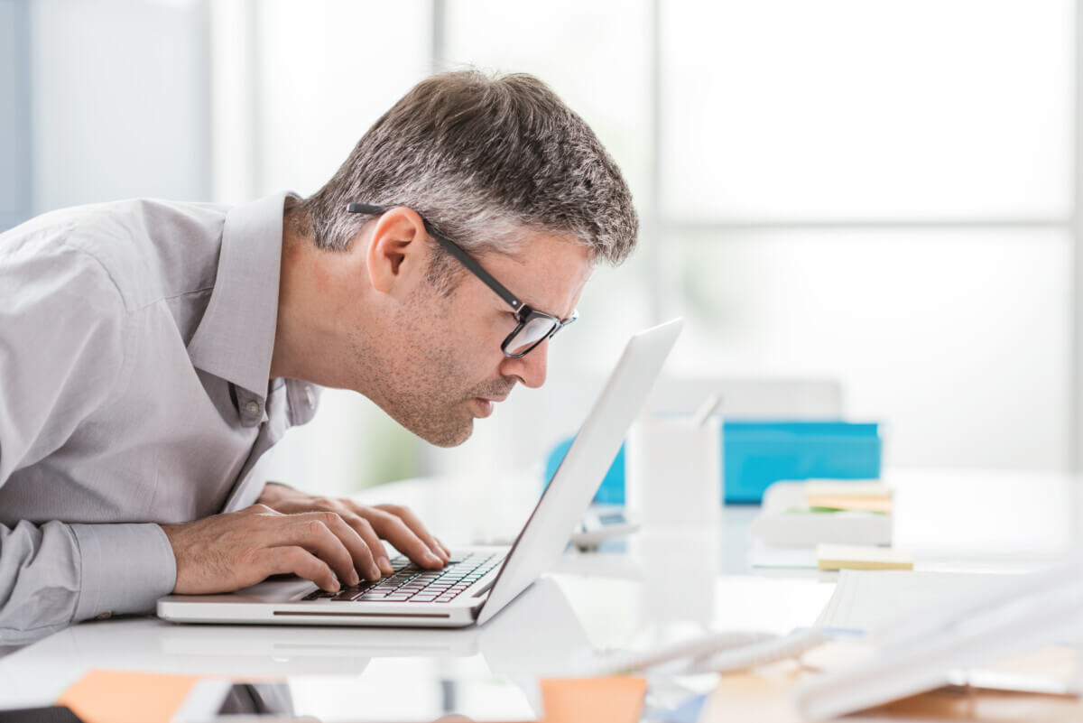Man battling vision problems, macular degeneration effects while looking at computer