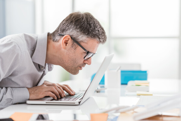 Man battling vision problems, macular degeneration effects while looking at computer