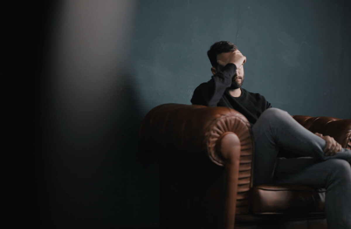 Man on couch sad, upset