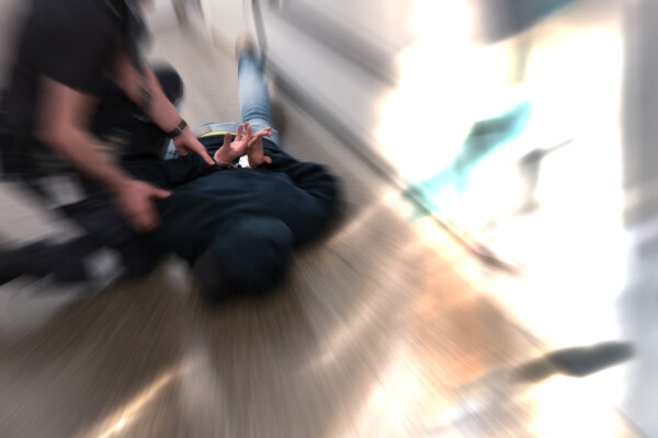 Police officer restraining suspect resisting arrest, placed in handcuffs
