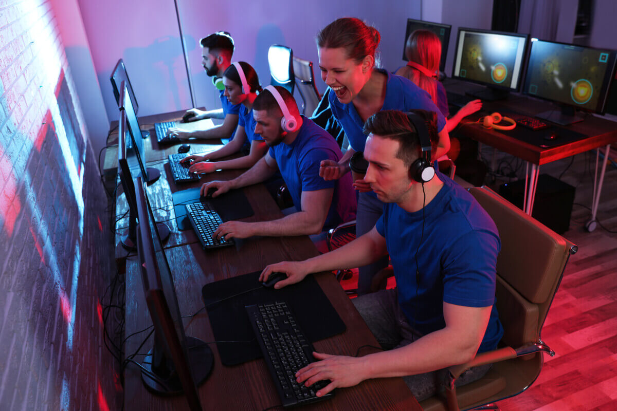 Young people playing video games on computers indoors. Esports tournament