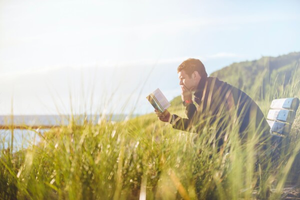 Man reading book outside