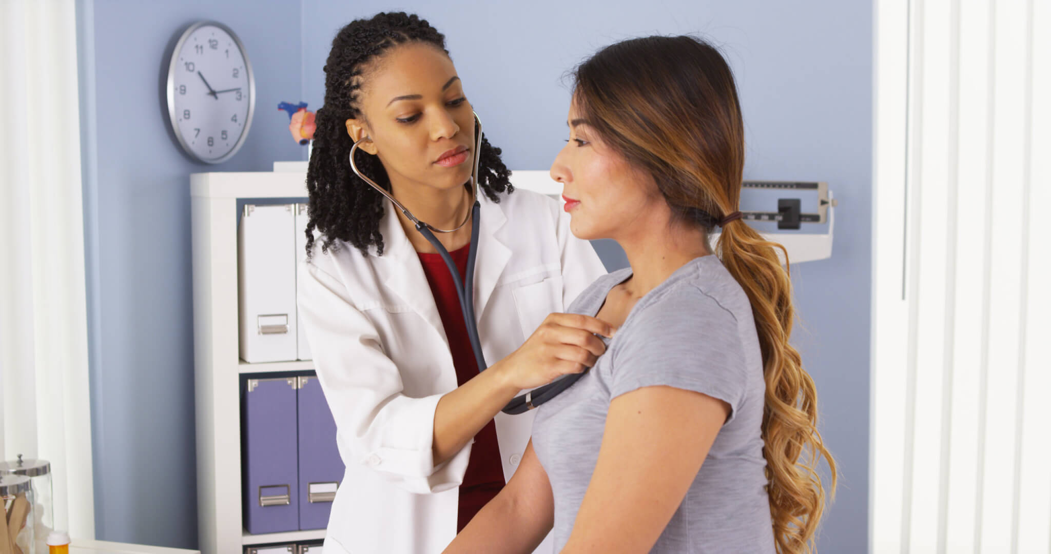 Doctor listening to woman's heart