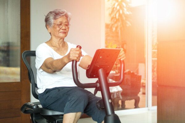 Older senior women using exercise bike