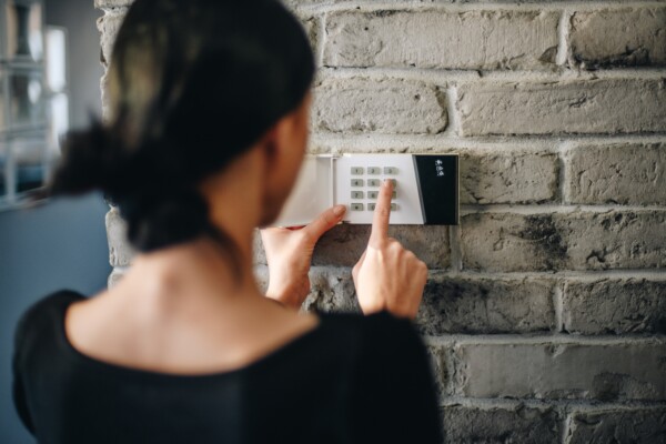 Woman turning on home alarm security system