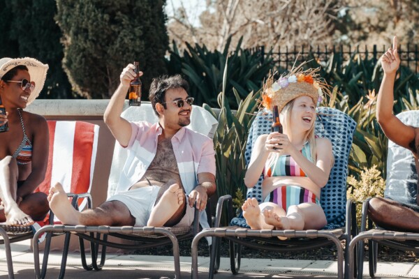 Friend having drinks by the pool, enjoying summer vacation