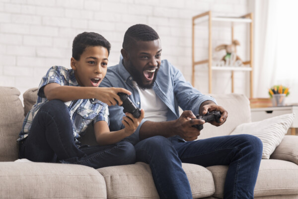 Father, son playing video games together