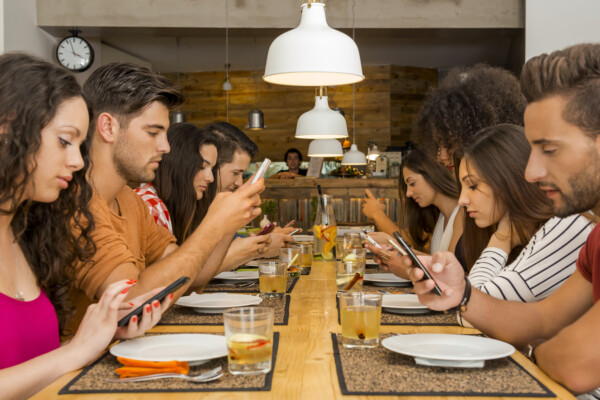 People staring at phone screens at dinner