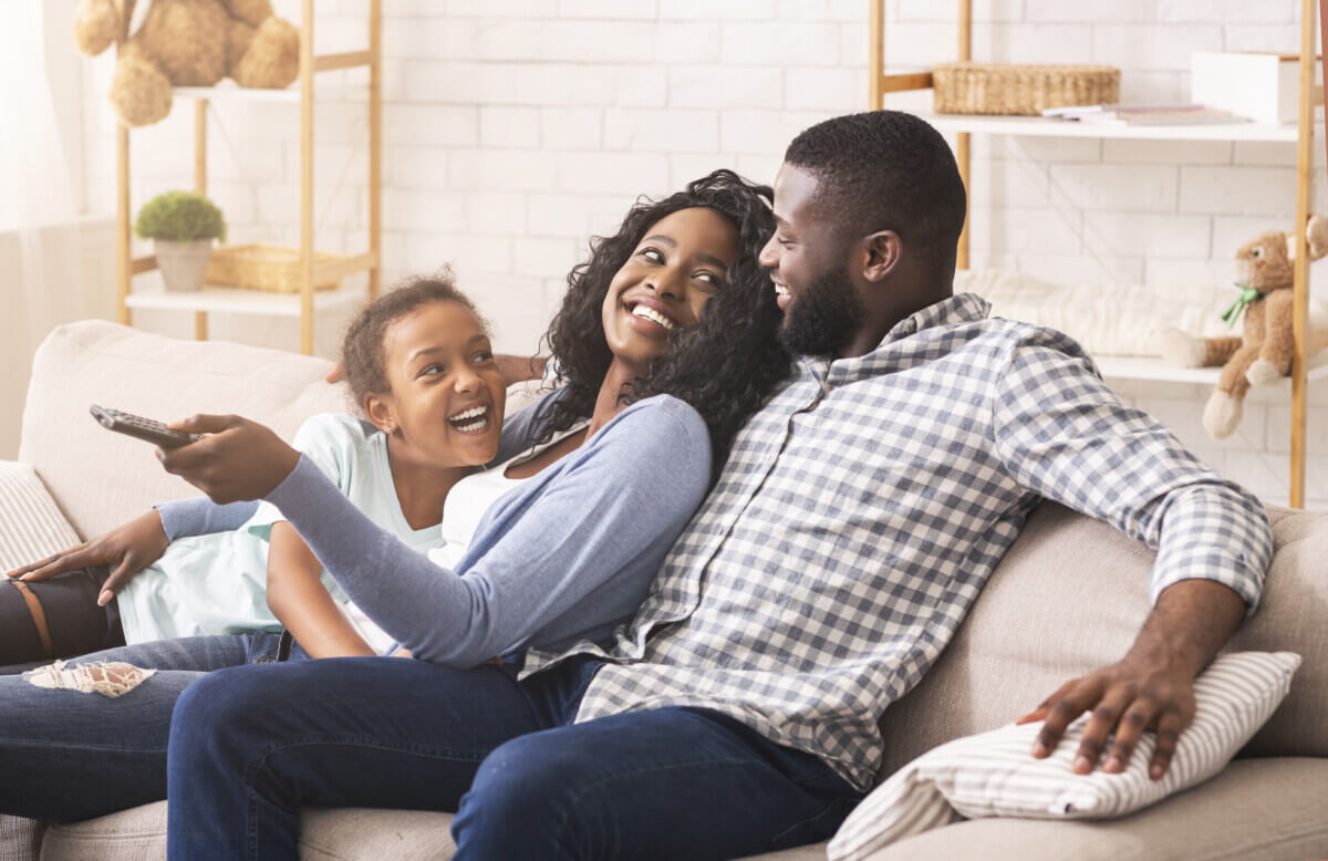 Joyful family having fun together, relaxing on sofa at home