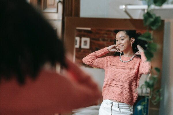 Confident woman looking at herself in the mirror