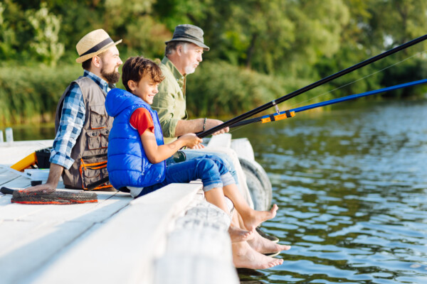 Boy fishing with his father and grandfather