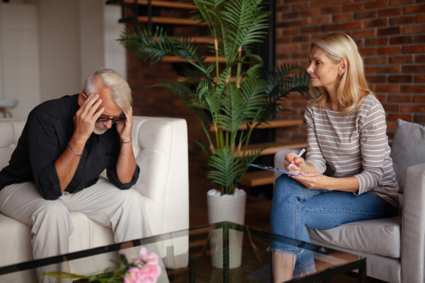 Older man talking to psychologist, therapist