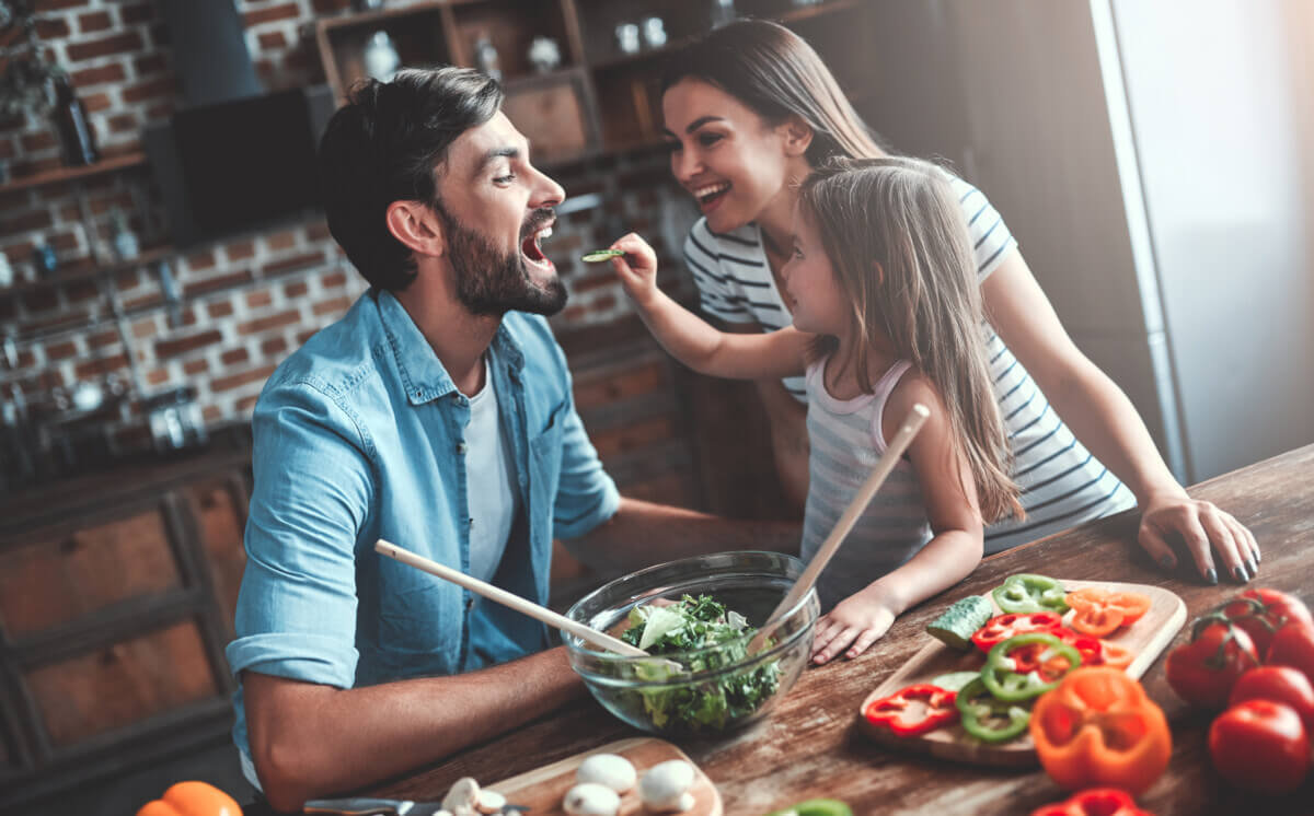 Parents cooking salad and vegetables with parents