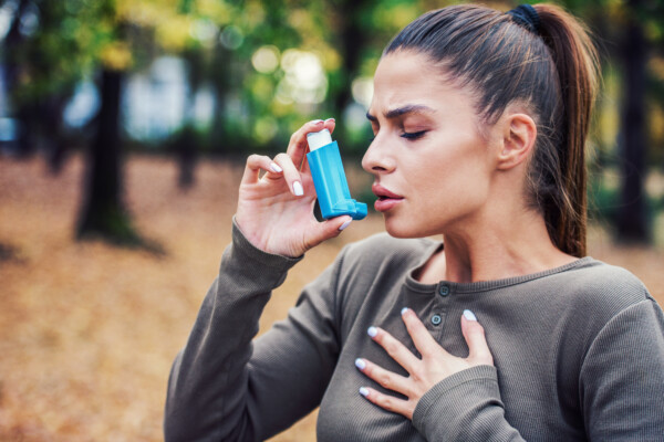 Woman with asthma using inhaler