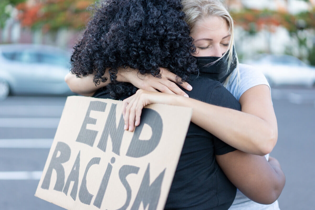 Black woman hugging a White woman at civil rights protest