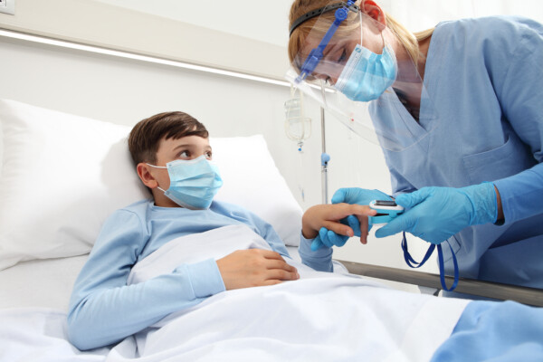 Nurse helping child COVID patient in hospital