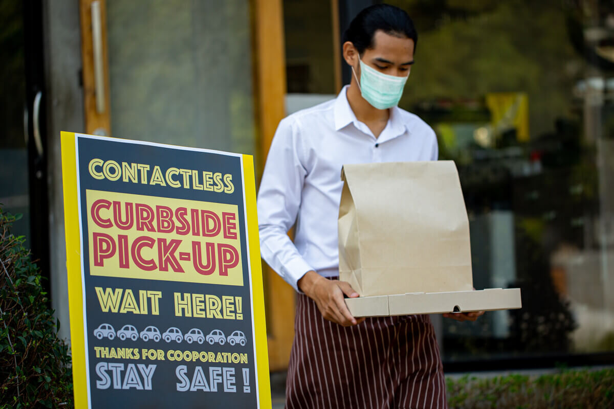 Curbside pick up.Store worker wear mark and bring  foods from cu