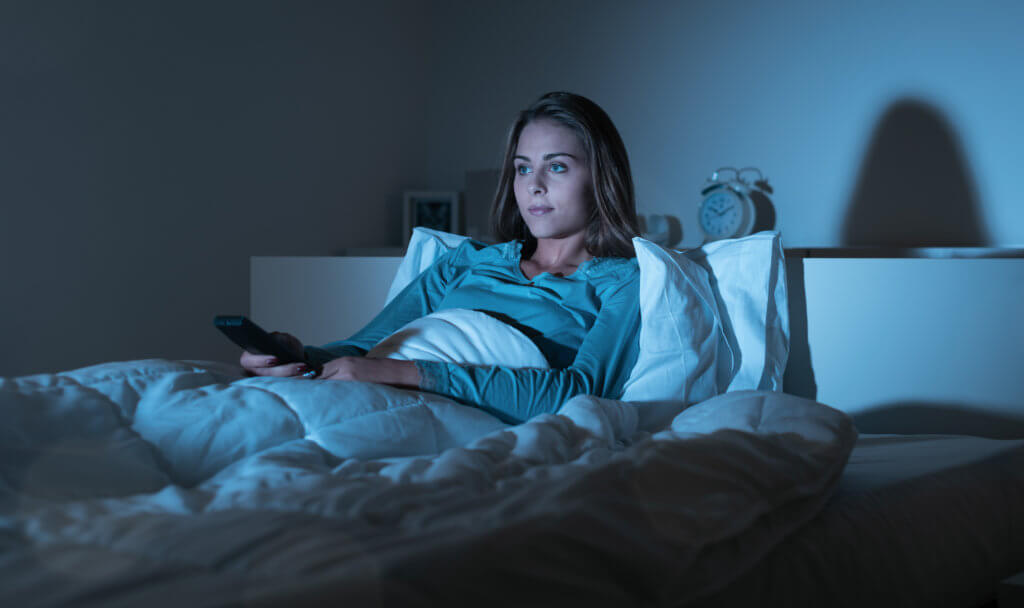 Woman watching TV or movie in bed