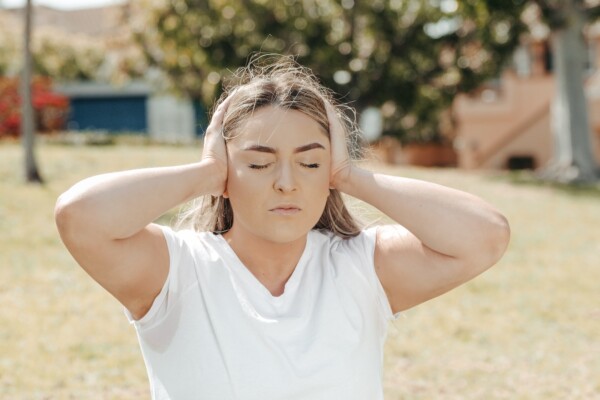 Woman covering ears, can't hear, too loud