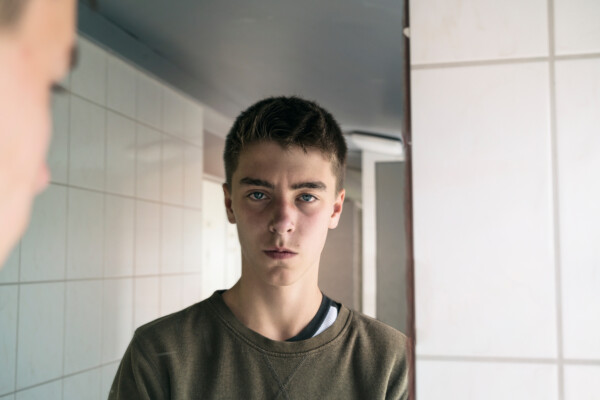 Teen boy looking in mirror