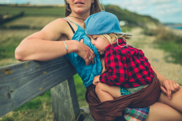 Mother breastfeeds toddler