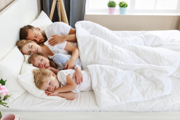 Parents and children sleeping, co-sharing bed