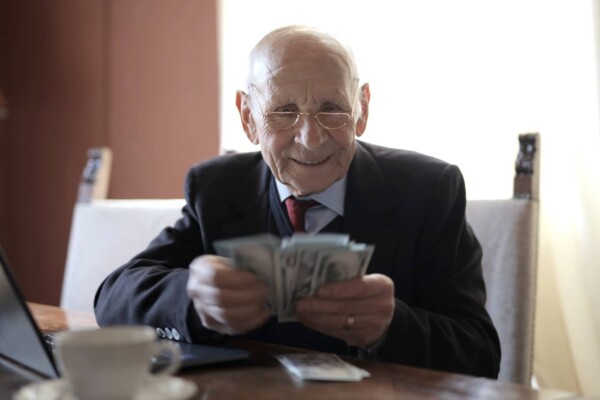 Older man in business suit looking at money