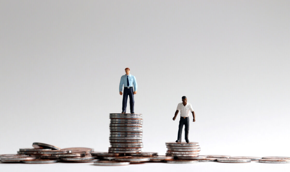 Racial wage gap concept. Miniature people standing on a pile of