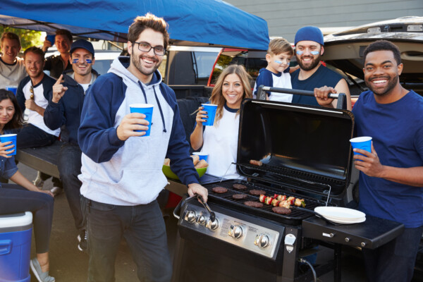 Group Of Sports Fans Tailgating In Stadium Car Parking Lot