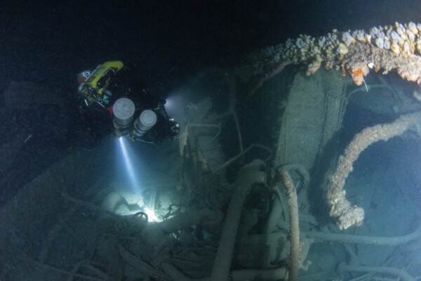 Diver Dom Robinson lighting up the silt over the wreck.
