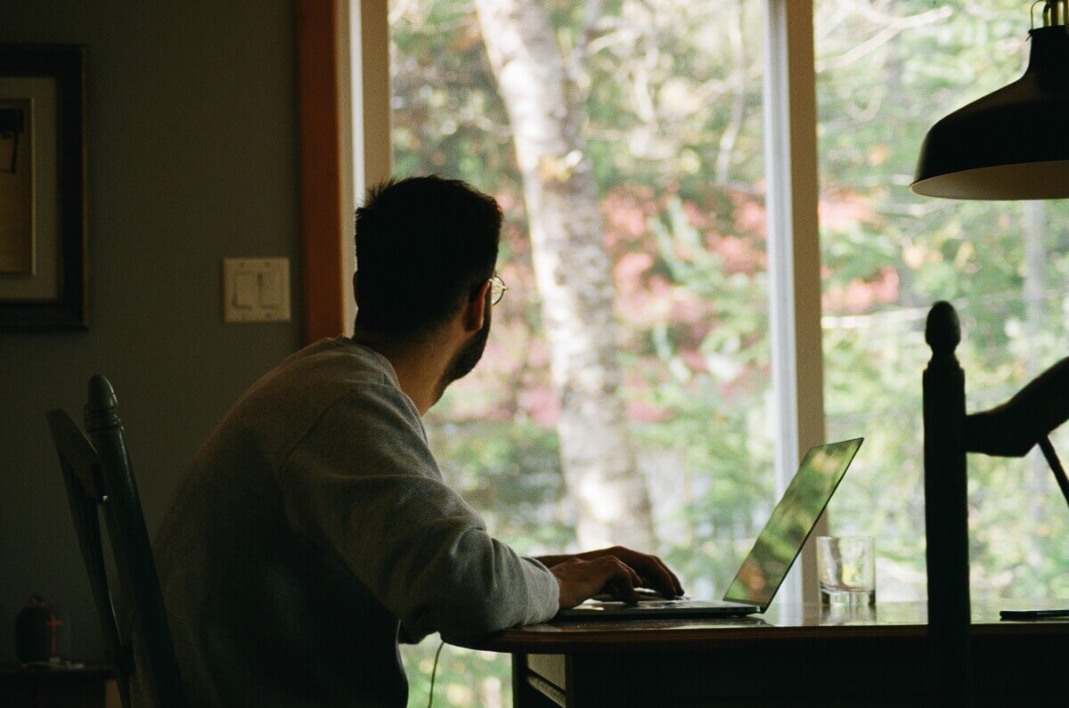 Man sitting at desk and looking outside window