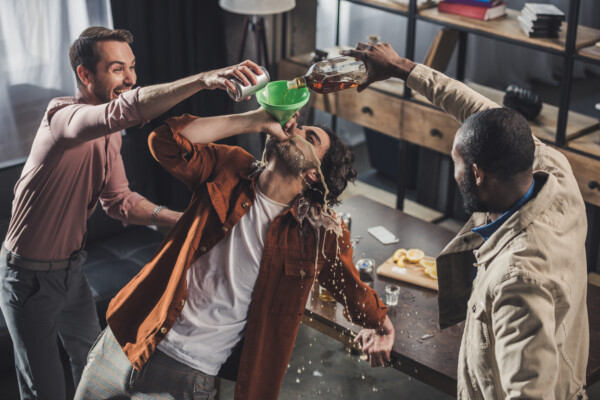 Friends getting drunk, funneling beer and alcohol at party