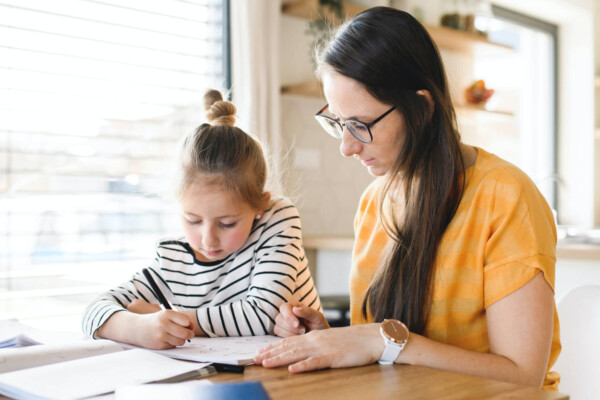 Mother helping child study and do homework